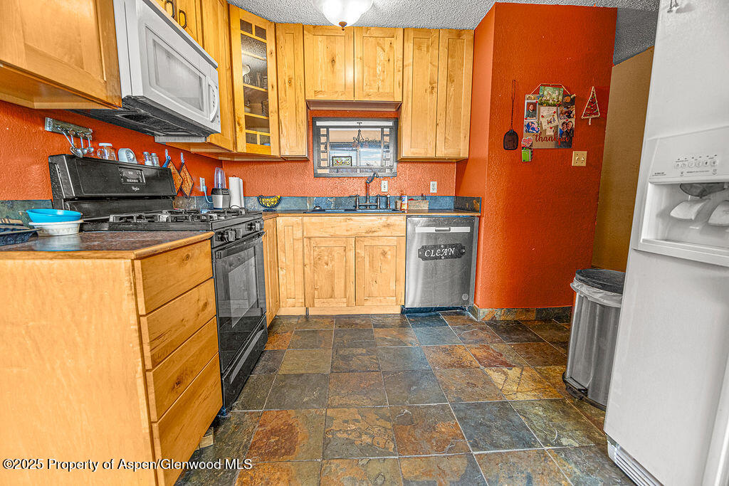 834 Ashley Road Craig, CO 81625 - Photo 4 of 38 a kitchen with stainless steel appliances granite countertop a stove a sink and a refrigerator