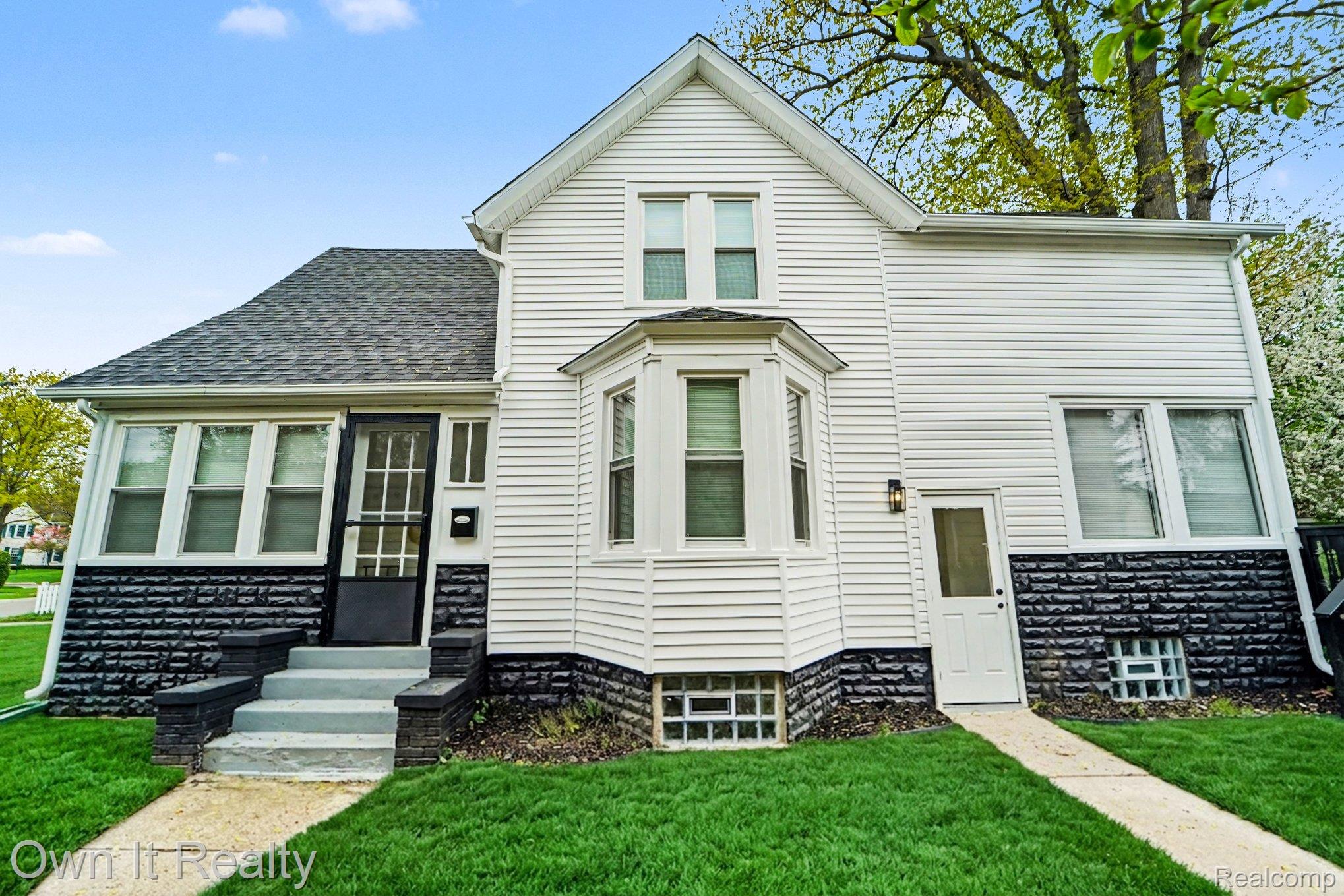 168 Kerby Road Grosse Pointe, MI 48236 - Photo 2 of 36 View of front of property featuring a front yard, entry steps, a shingled roof, and stone siding