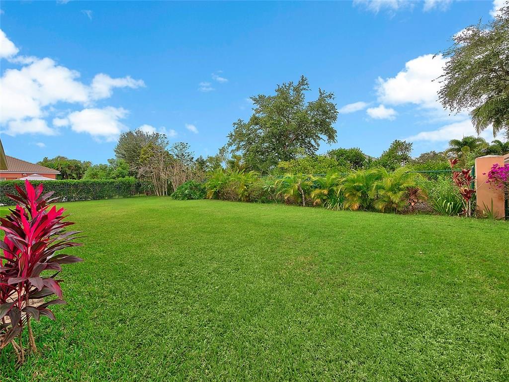1945 Southwest Panther Trace Stuart, FL 34997 - Photo 18 of 18 a view of a garden with a building in the background