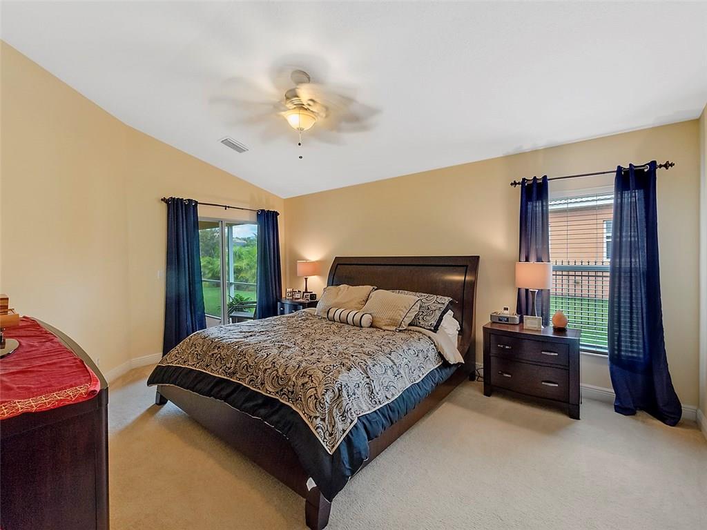 1945 Southwest Panther Trace Stuart, FL 34997 - Photo 8 of 18 a bedroom with a bed and a chandelier