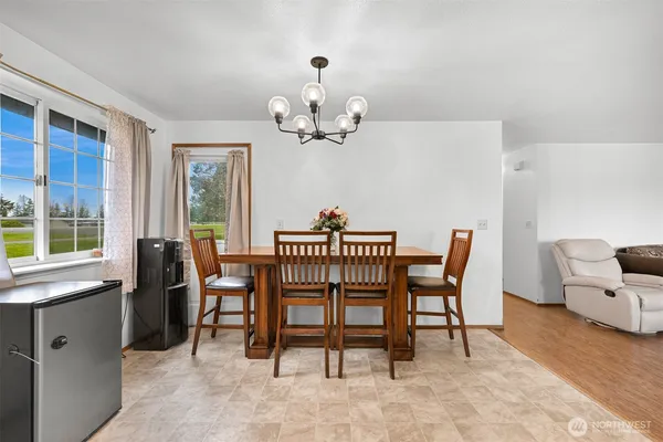 a view of a dining room with furniture a chandelier and a window