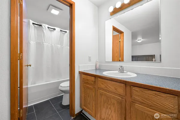 a bathroom with a granite countertop sink toilet and shower