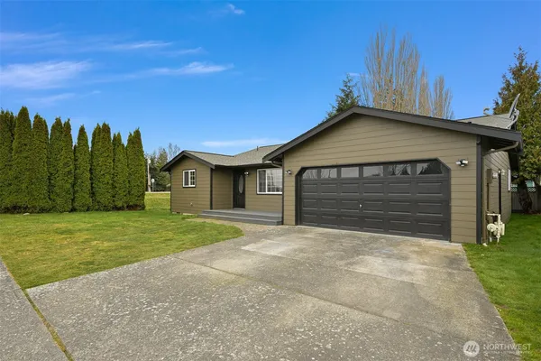 a front view of a house with a yard and garage