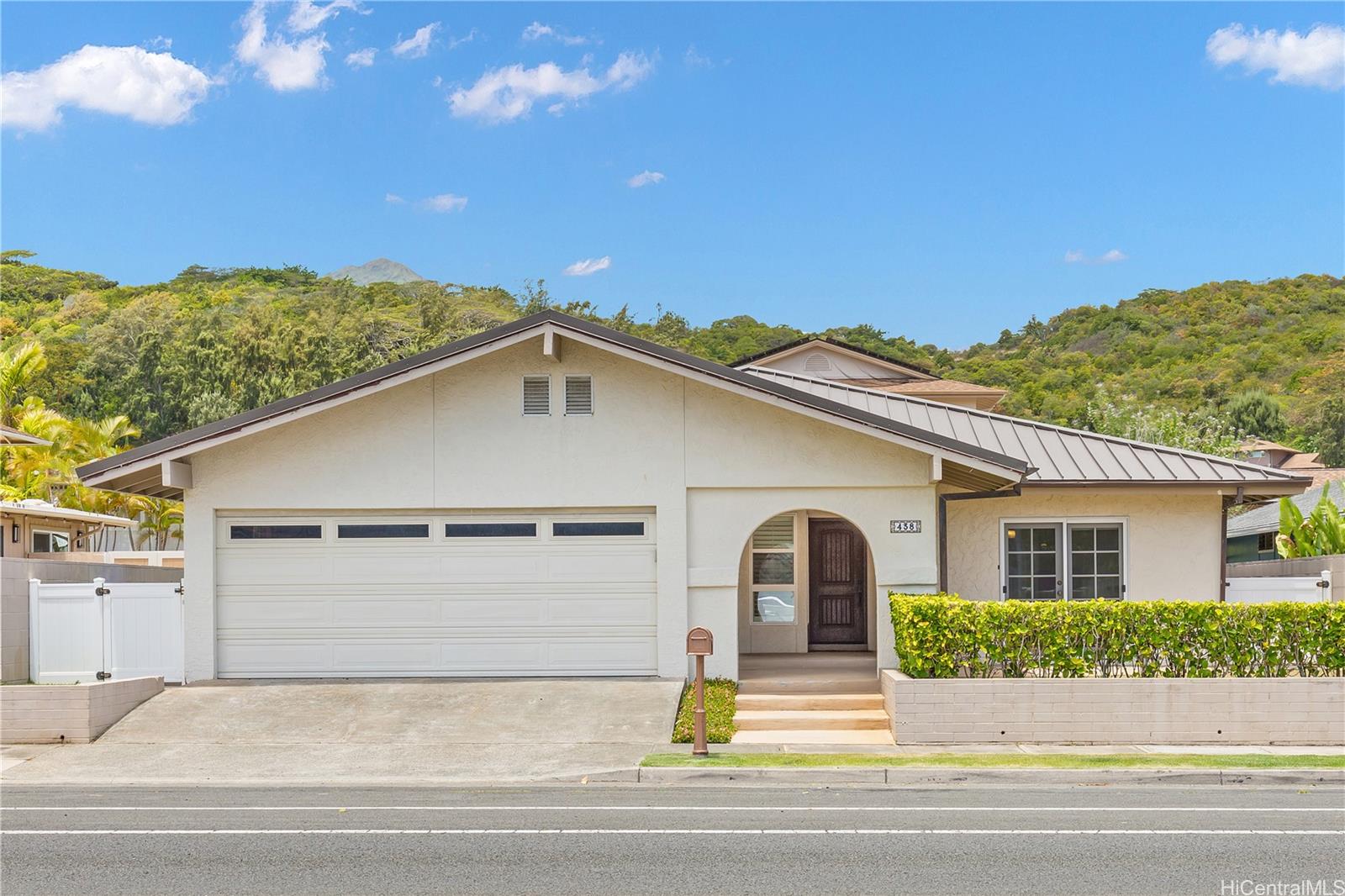 a view of a white house with a yard and plants