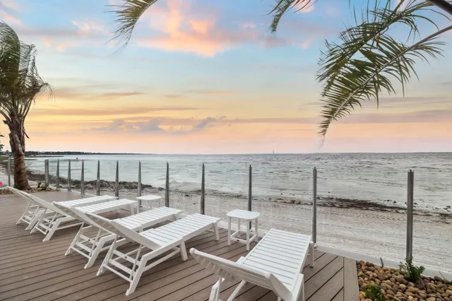 a kitchen with stainless steel appliances a sink a stove a refrigerator a center island and cabinets