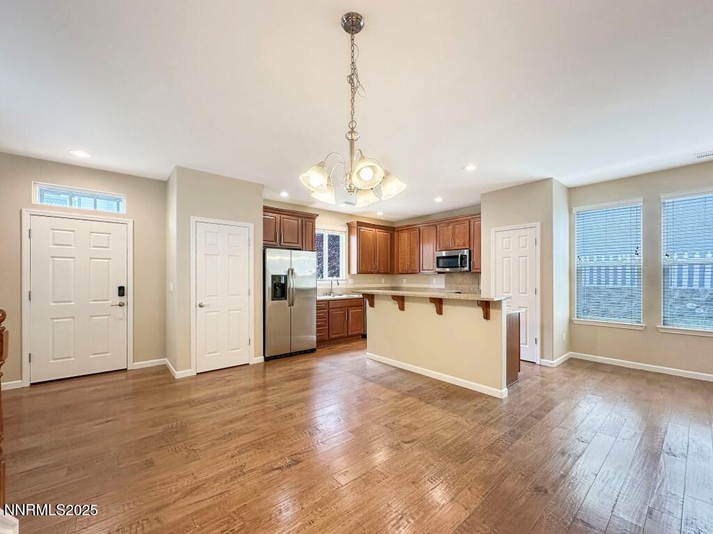 2180 Alamo Square Way Reno, NV 89509 - Photo 6 of 34 a view of a kitchen with kitchen island a sink wooden floor and stainless steel appliances