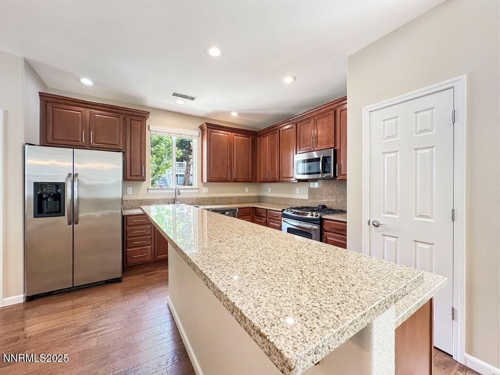 2180 Alamo Square Way Reno, NV 89509 - Photo 7 of 34 a kitchen with stainless steel appliances granite countertop a refrigerator a sink a stove a microwave and island