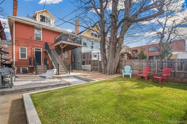 a view of a house with a backyard and a tree