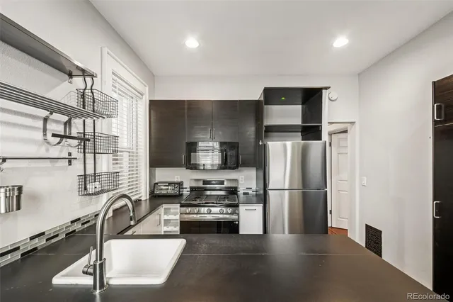 a kitchen with stainless steel appliances a refrigerator and a stove top oven