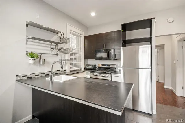 a kitchen with stainless steel appliances a refrigerator sink and microwave