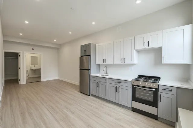 a kitchen with white cabinets and stainless steel appliances