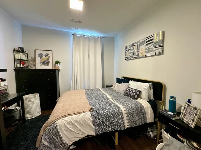a bedroom with a bed and wooden floor
