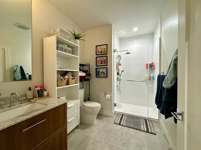 a bathroom with a granite countertop sink toilet and shower