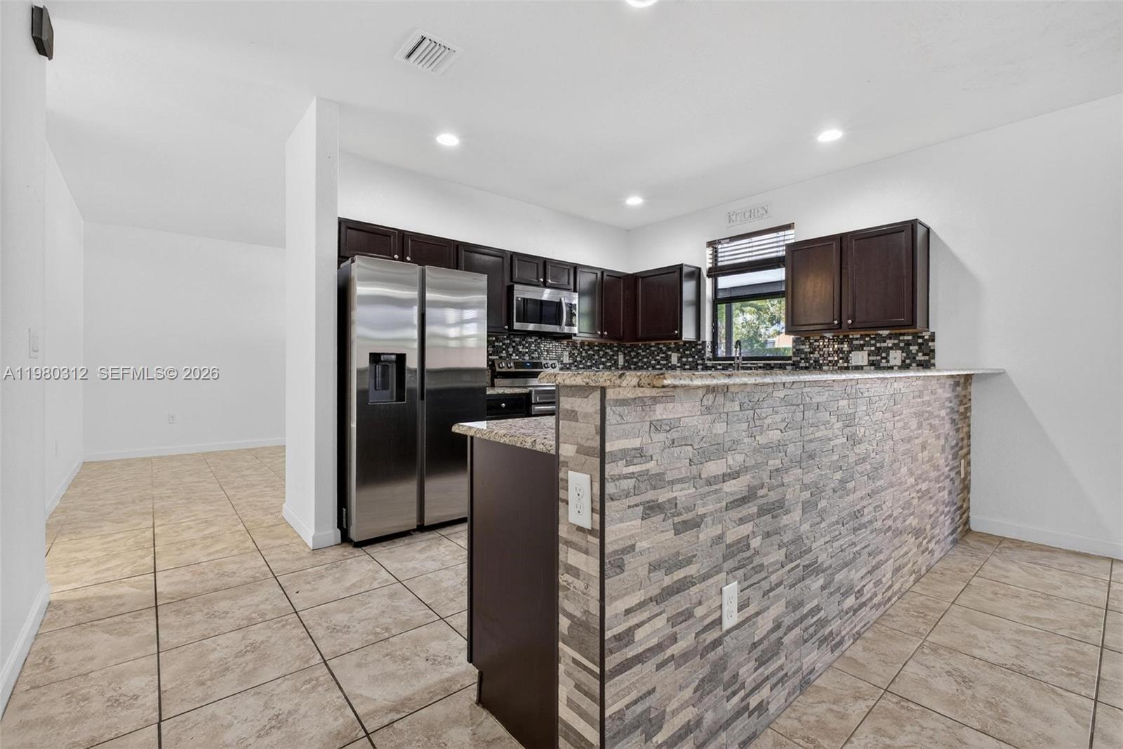 11561 Southwest 232nd Lane, Unit 11561 Homestead, FL 33032 - Photo 17 of 61 a kitchen with stainless steel appliances granite countertop a refrigerator and a stove