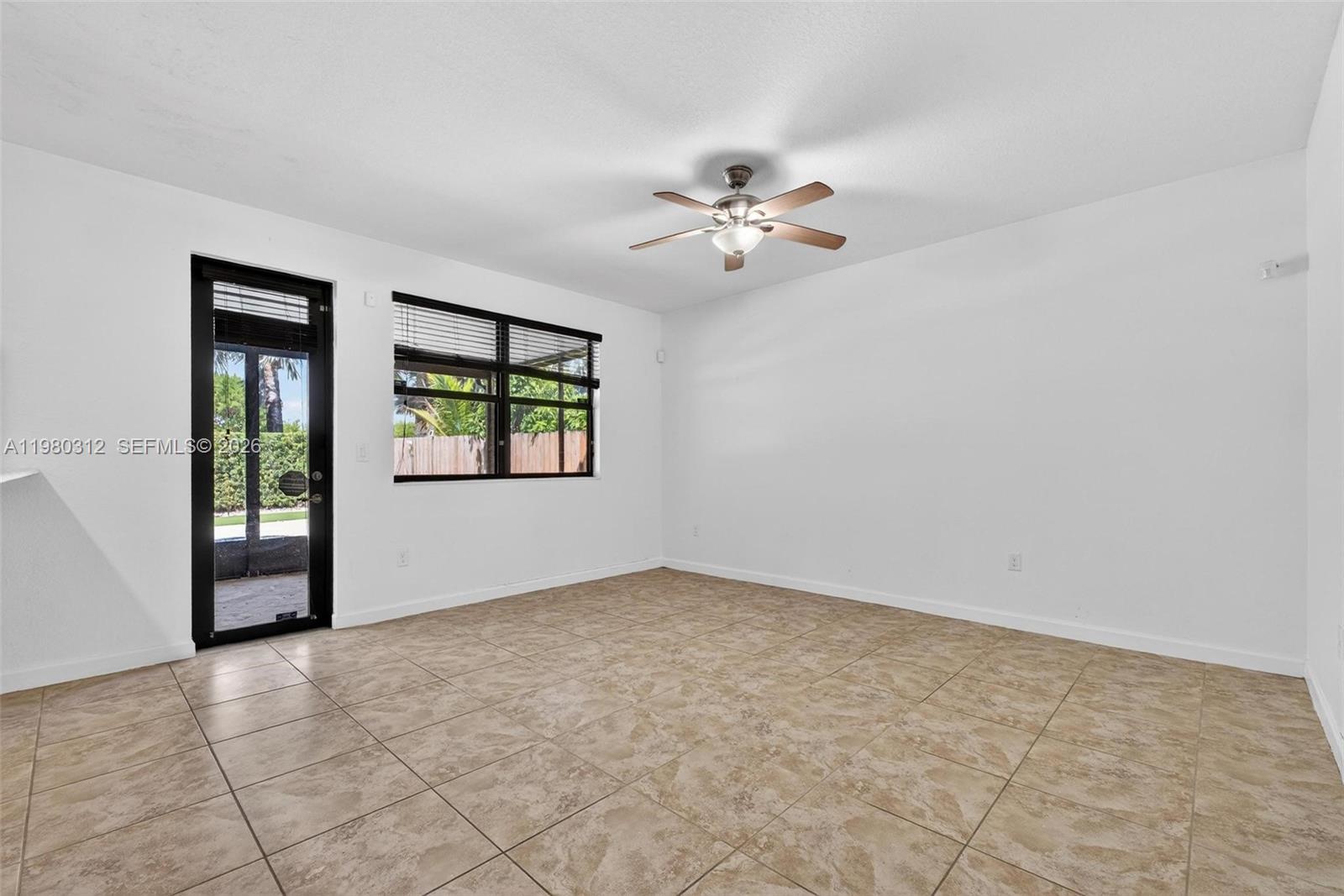 11561 Southwest 232nd Lane, Unit 11561 Homestead, FL 33032 - Photo 18 of 61 an empty room with windows and chandelier fan