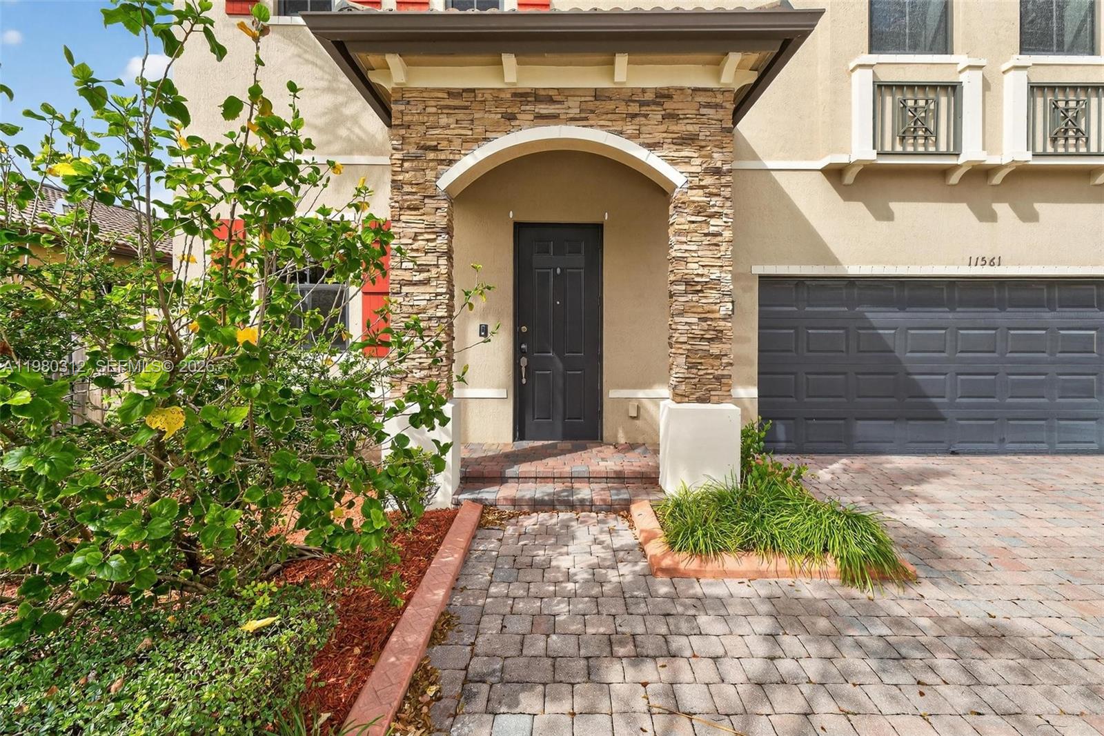 11561 Southwest 232nd Lane, Unit 11561 Homestead, FL 33032 - Photo 2 of 61 a front view of a house with garden