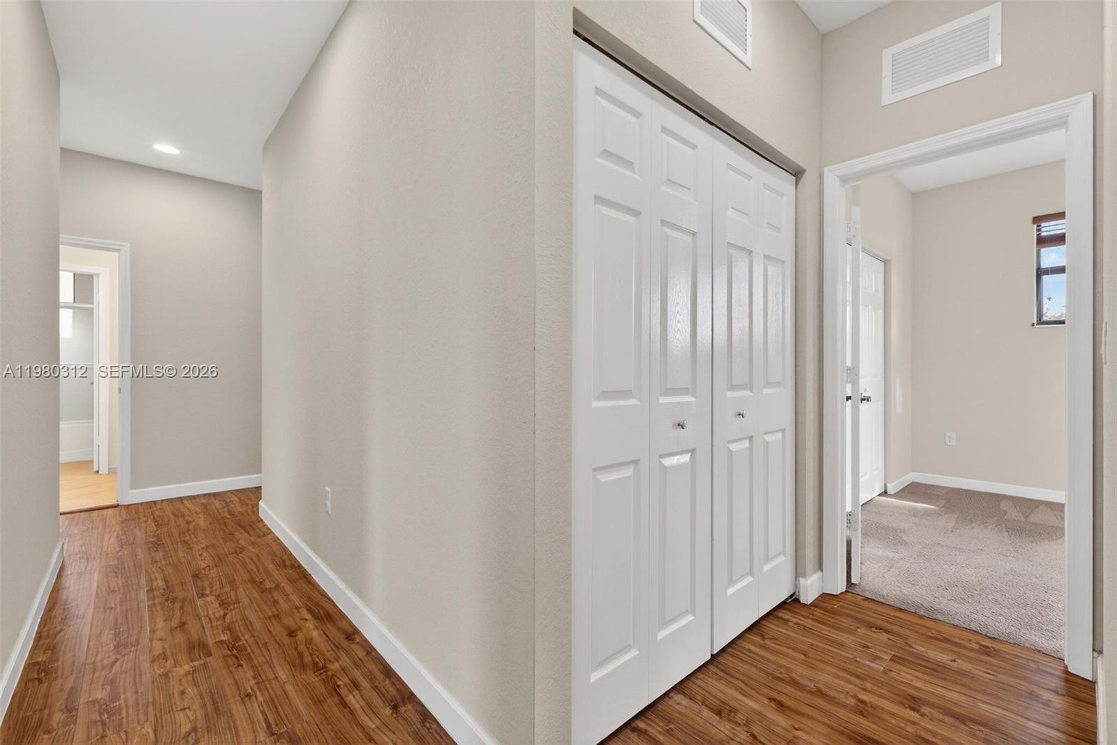 11561 Southwest 232nd Lane, Unit 11561 Homestead, FL 33032 - Photo 27 of 61 a view of a hallway with wooden floor and closet area