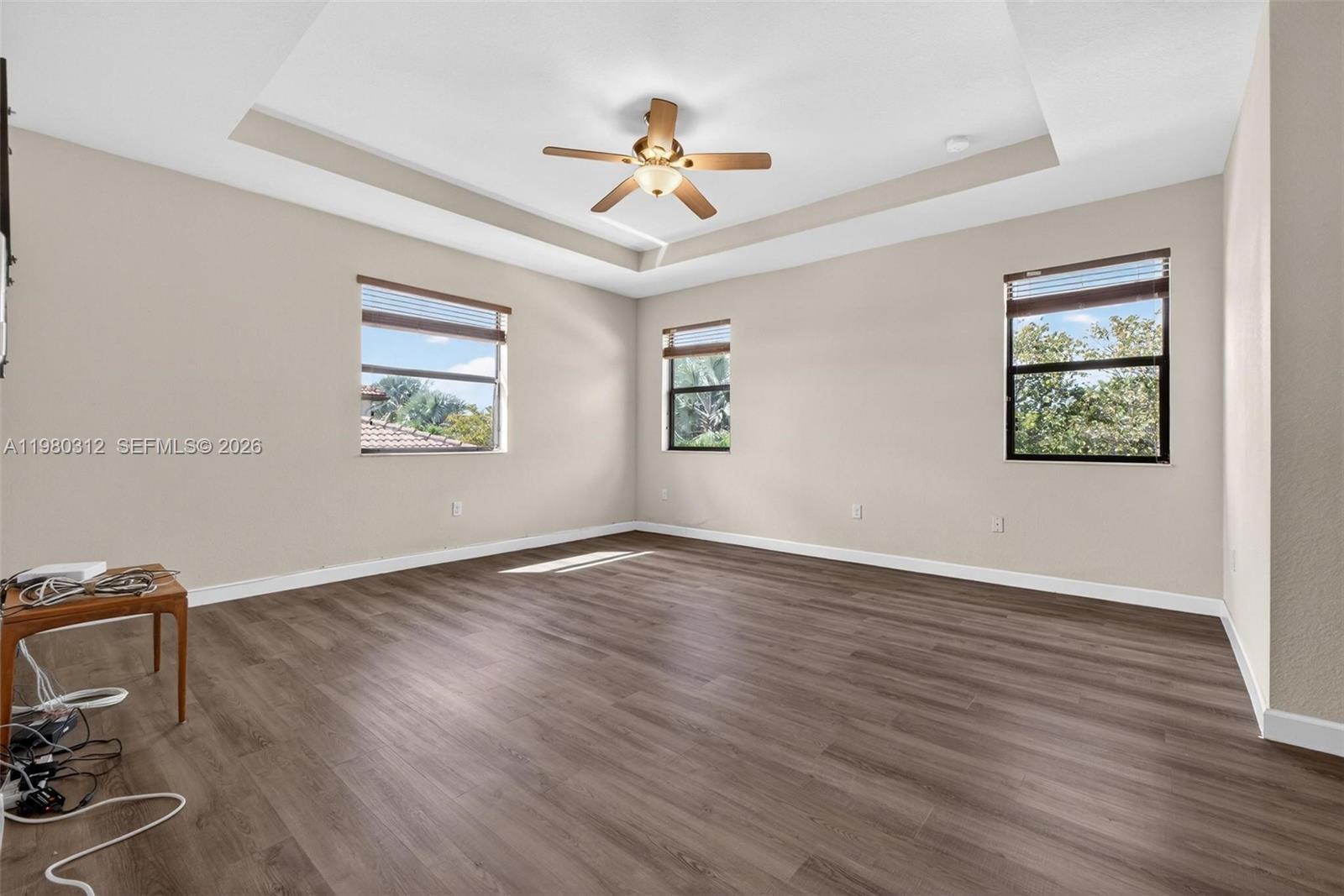 11561 Southwest 232nd Lane, Unit 11561 Homestead, FL 33032 - Photo 29 of 61 a view of an empty room with wooden floor and a ceiling fan