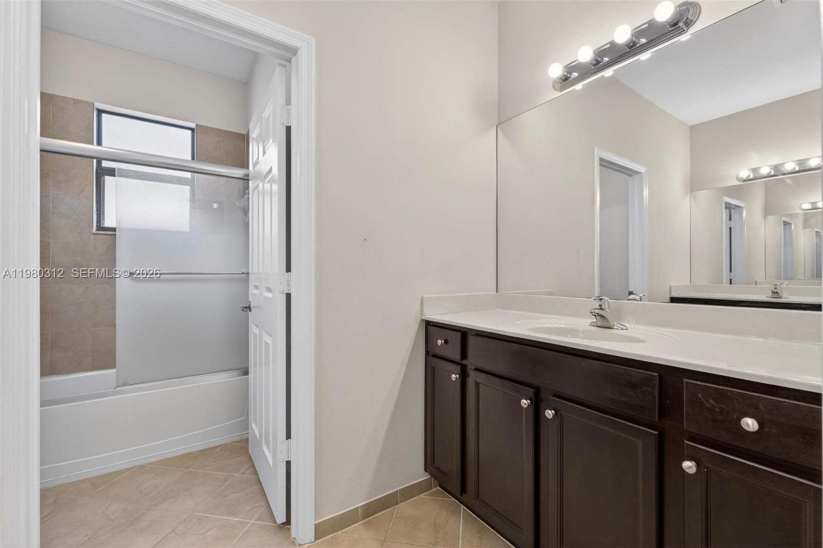 11561 Southwest 232nd Lane, Unit 11561 Homestead, FL 33032 - Photo 40 of 61 a bathroom with a double vanity sink a mirror and a shower