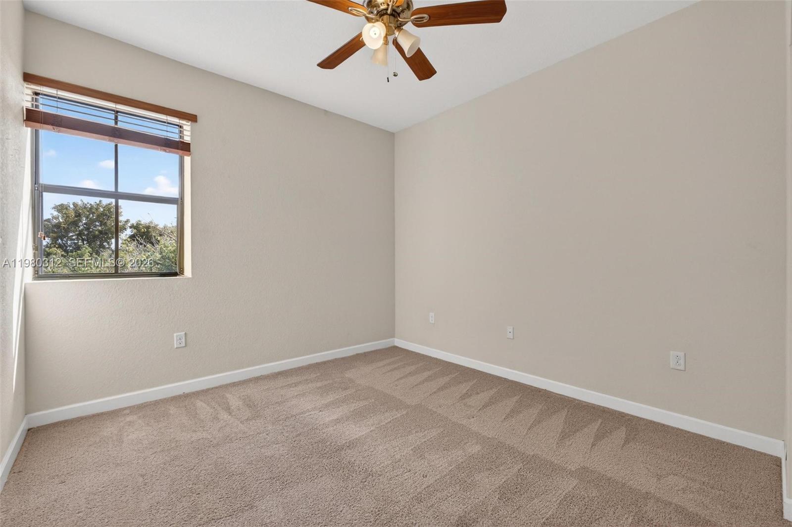 11561 Southwest 232nd Lane, Unit 11561 Homestead, FL 33032 - Photo 43 of 61 an empty room with a window and a ceiling fan