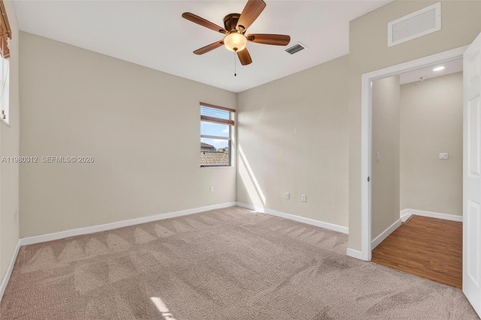 11561 Southwest 232nd Lane, Unit 11561 Homestead, FL 33032 - Photo 45 of 61 a view of a room with a ceiling fan and a window