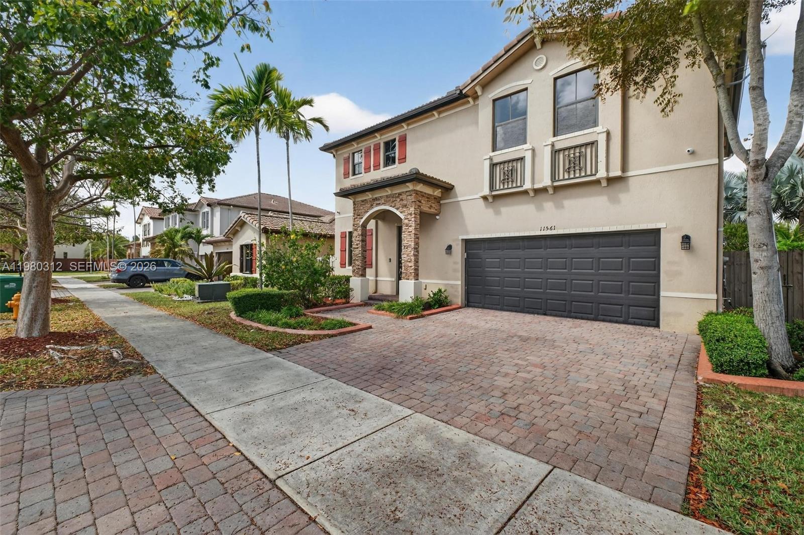 11561 Southwest 232nd Lane, Unit 11561 Homestead, FL 33032 - Photo 60 of 61 a front view of a house with a yard and garage