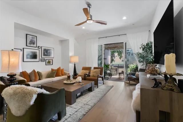 a living room with furniture chandelier and a flat screen tv