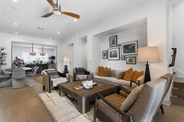 a living room with furniture a chandelier and a dining table