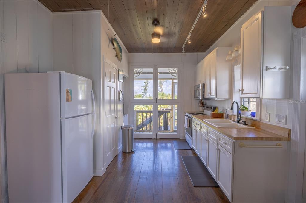 8796 Grand Avenue Boca Grande, FL 33921 - Photo 14 of 19 a kitchen with sink a refrigerator and wooden floors