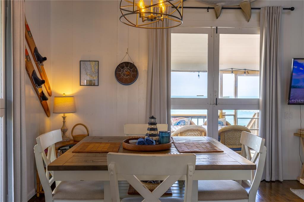 8796 Grand Avenue Boca Grande, FL 33921 - Photo 15 of 19 a view of a dining room with furniture a chandelier and wooden floor