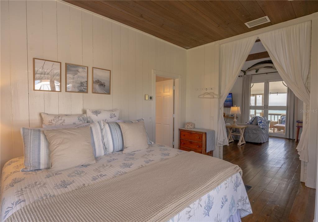 8796 Grand Avenue Boca Grande, FL 33921 - Photo 16 of 19 a bedroom with a large bed and a chandelier