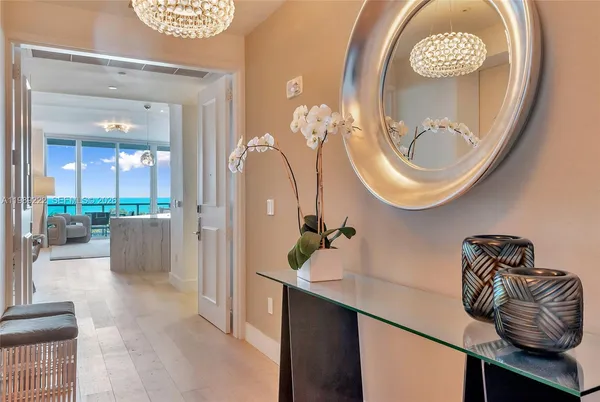 a view of a hallway with furniture and mirror