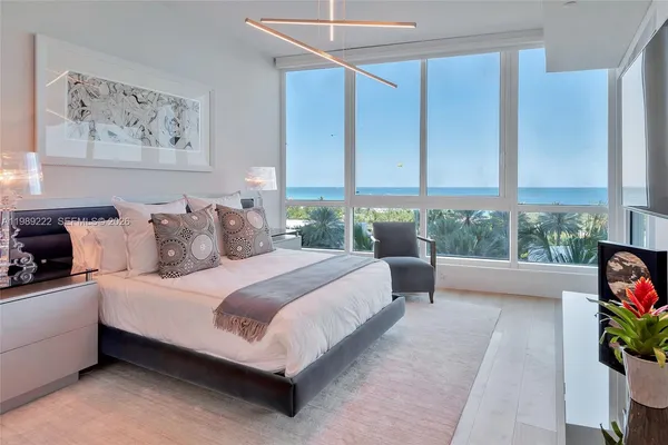a bedroom with a bed and a potted plant on the dresser