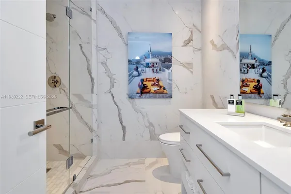 a bathroom with a sink vanity mirror and toilet