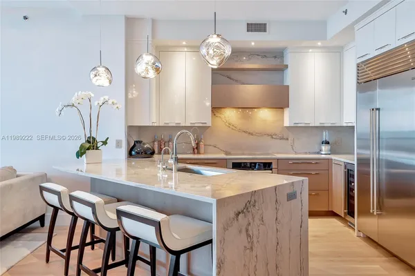 a kitchen with a dining table chairs cabinets and stainless steel appliances