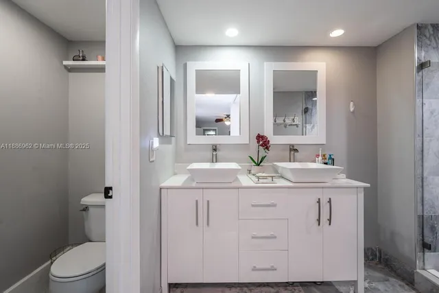 a bathroom with a granite countertop sink a toilet and a mirror