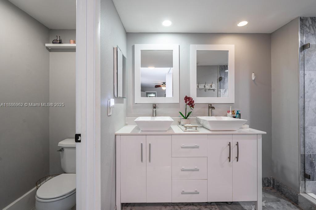 9146 Southwest 23rd Street Davie, FL 33324 - Photo 11 of 21 a bathroom with a granite countertop sink a toilet and a mirror