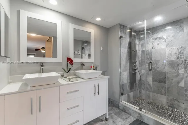 a bathroom with a shower sink vanity and mirror