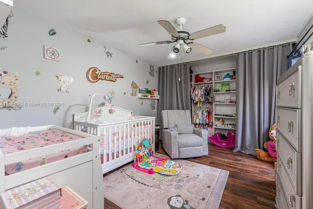 a bedroom with baby bed and a window