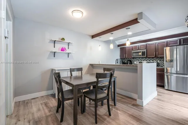 a view of kitchen with refrigerator dining table and chairs