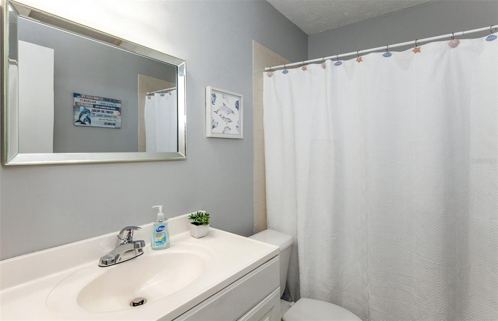 140 Columbia Road Venice, FL 34293 - Photo 17 of 30 a bathroom with a sink a mirror and a shower curtain