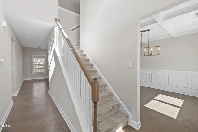 a view of an empty room with a fireplace and wooden floor