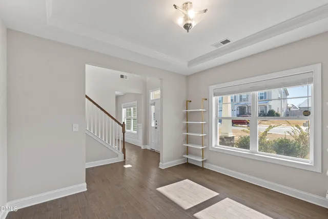 an empty room with windows fireplace and wooden floor