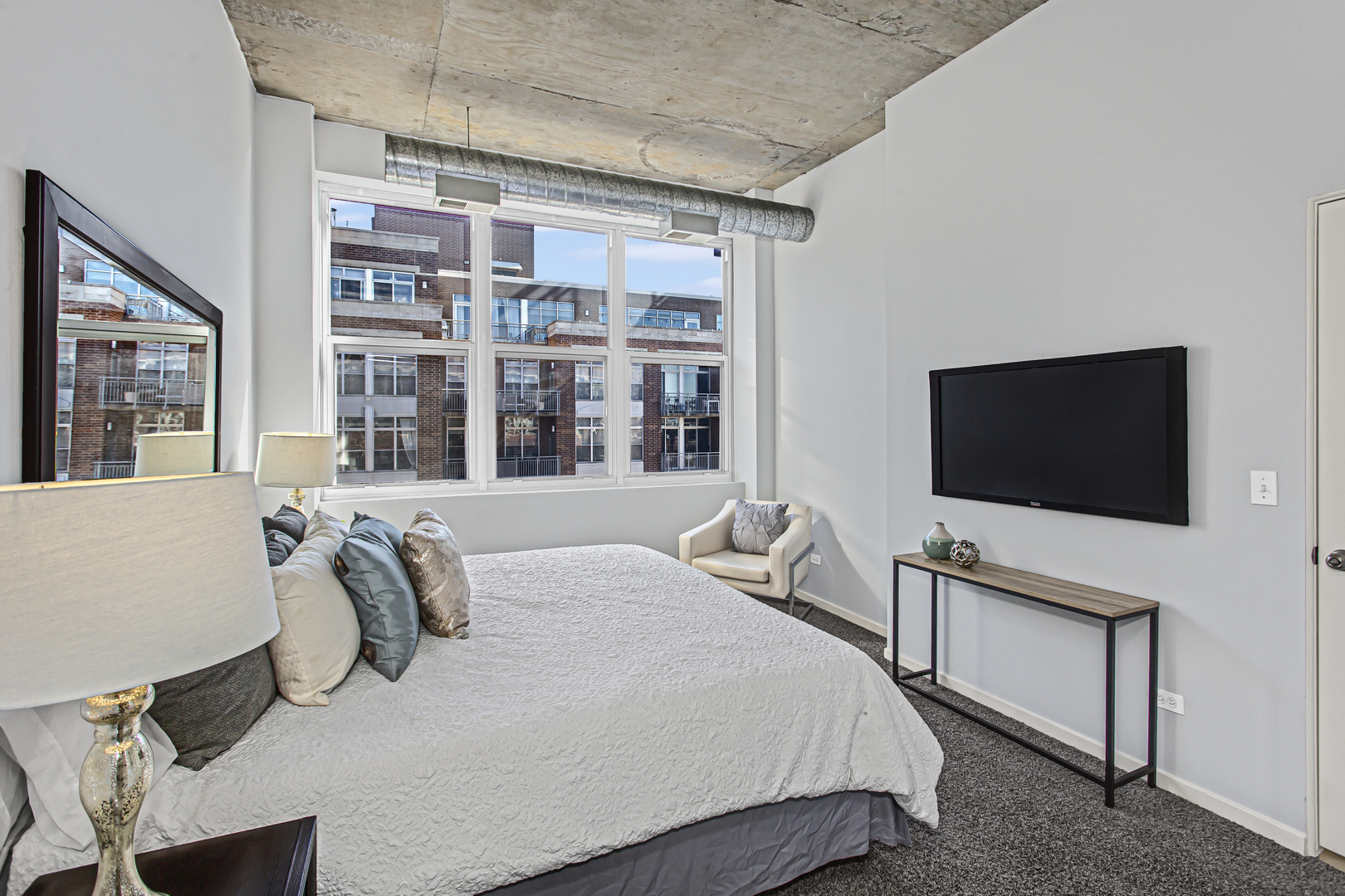 1000 West Adams Street, Unit 706 Chicago, IL 60607 - Photo 8 of 9 a bedroom with a bed and a flat screen tv