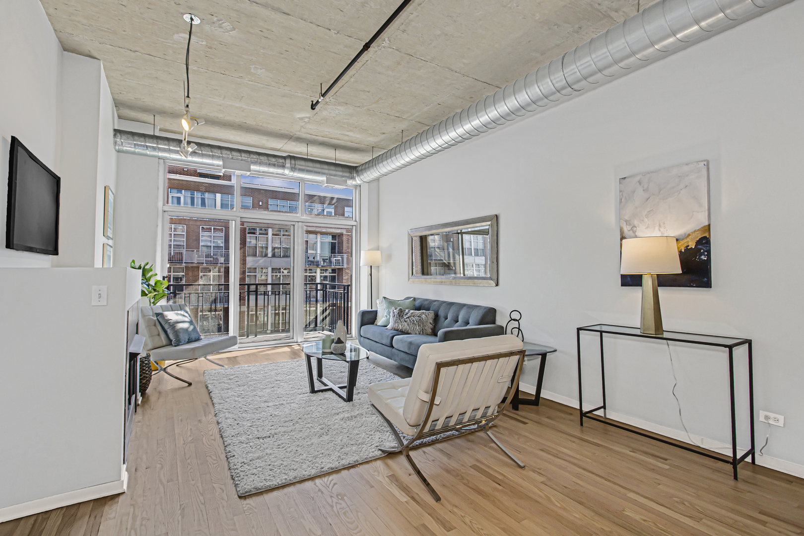 1000 West Adams Street, Unit 706 Chicago, IL 60607 - Photo 3 of 9 a living room with furniture and a lamp