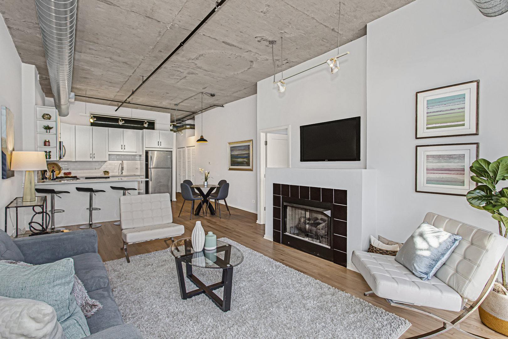 1000 West Adams Street, Unit 706 Chicago, IL 60607 - Photo 6 of 9 a living room with furniture a fireplace and a flat screen tv