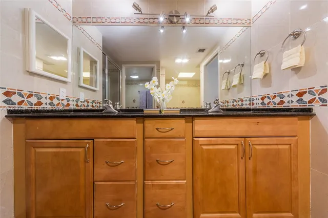 a bathroom with a sink a mirror and a shower