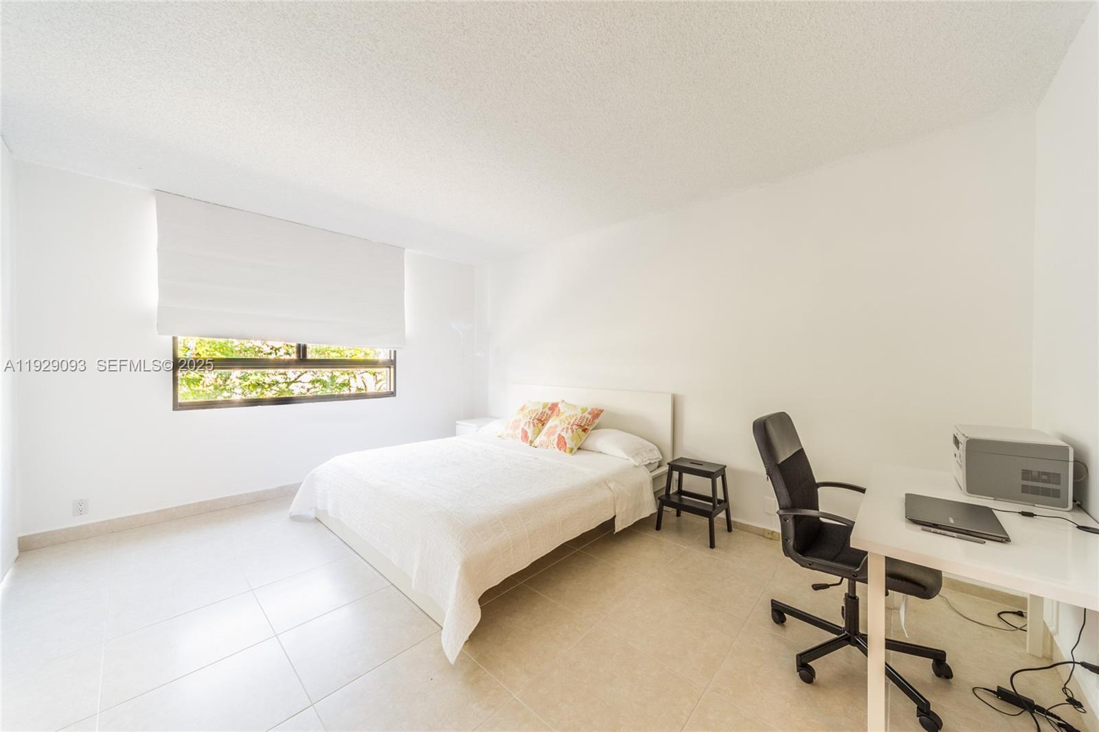 121 Crandon Boulevard, Unit 248 Key Biscayne, FL 33149 - Photo 20 of 37 a bedroom with a bed a desk and chair