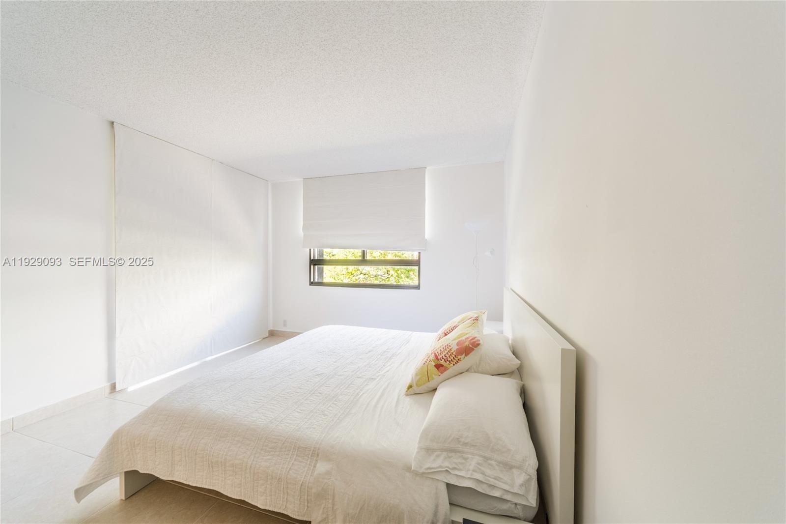 121 Crandon Boulevard, Unit 248 Key Biscayne, FL 33149 - Photo 21 of 37 a bedroom with a bed and a window