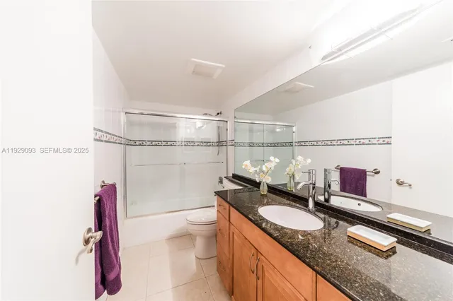 a bathroom with a granite countertop sink a toilet and a shower